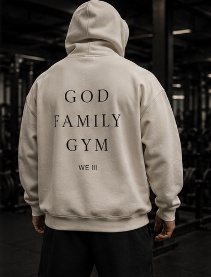 Model wearing the WE III cream God Family Gym hoodie in a gym